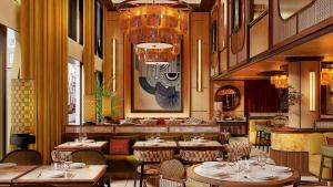 a restaurant with tables and chairs and a chandelier at Petra Hotel Belgrade in Belgrade
