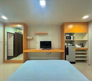 a bedroom with a bed and a desk and a refrigerator at Peaberry Place - พีเบอร์รี่เพลส in Ban Zong Katiam