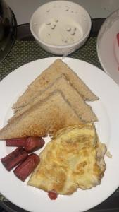 a plate of breakfast food with eggs sausage and toast at Star Haven Hotel and suites in Badore