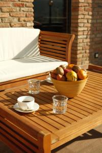 a wooden table with a bowl of fruit on it at Galavani By Vintage Hotel Collections in Tbilisi City +69 photos