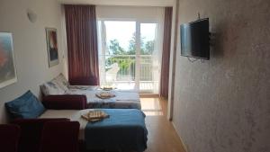 a living room with two beds and a television at Sunny House Byala in Byala