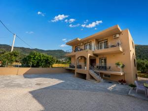a large house with a balcony and mountains in the background at Katsanikos House in Prinos