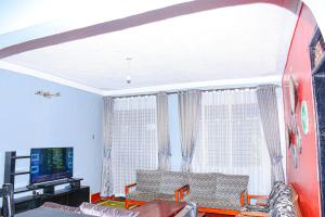 a living room with a couch and a tv at Larry Homestay in Kapchorwa