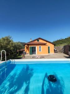 a house and a swimming pool with a house at Manu & Manu Rooms in Garlenda