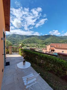 a white table and chairs on a patio with mountains at Manu & Manu Rooms in Garlenda