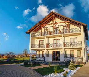 a house with a balcony on a blue sky at La SOFIIA in Săpânța
