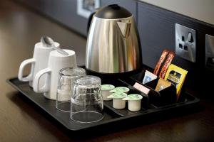 a tray with a tea kettle and cups on a table at Wirral Park Hotel in Greasby