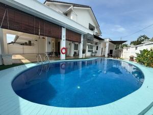 a large blue swimming pool in front of a house at Seri Botani Private Pool Villa 5BR in Ipoh
