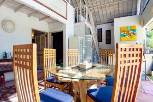 a dining room with a glass table and chairs at Villa Raquel by Betterplace in Seminyak