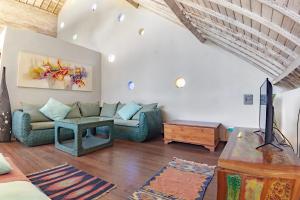 a living room with a couch and a table at Villa Raquel by Betterplace in Seminyak