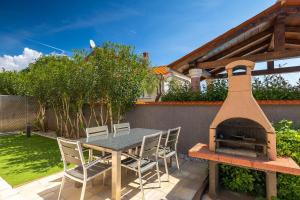 a patio with a table and a pizza oven at Villa Lara 1 in Ližnjan