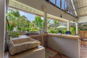 a kitchen with a sink and a large window at Villa Raquel by Betterplace in Seminyak