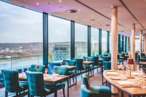 a restaurant with tables and chairs and large windows at Radisson Blu Hotel, Bonn in Bonn