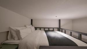 a bedroom with a bed with white sheets and pillows at Anook Hotel Ulsan Mugeo in Ulsan