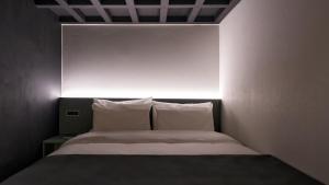 a bed with white pillows in a small room at Anook Hotel Ulsan Mugeo in Ulsan