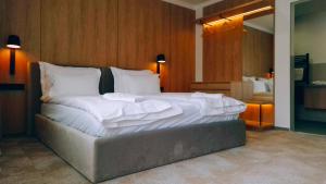 a bedroom with a large bed with white sheets at Marisel Escape Chalet in Mărişel