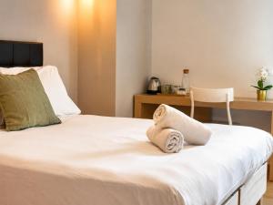 a bedroom with a bed with towels on it at Hotel Radis in Forni di Sotto