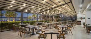 a restaurant with tables and chairs and large windows at The Komana Dardanelles in Hamidiye