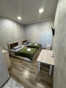 a room with two beds and a table in it at Hotel Hovit in Bagratashen