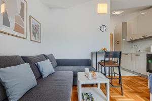 a living room with a couch and a table at Apartment Vallera in Medulin +14 photos