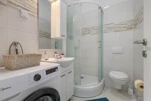 a white bathroom with a washing machine in it at Apartment Vallera in Medulin