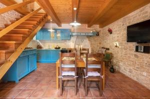 a kitchen with blue cabinets and a wooden table at House Luca in Barban