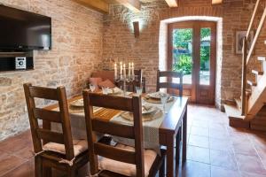 a dining room with a table and a tv at House Luca in Barban