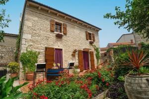 a stone house with a garden in front of it at House Luca in Barban