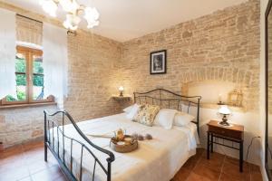 a bedroom with a bed and a brick wall at House Luca in Barban