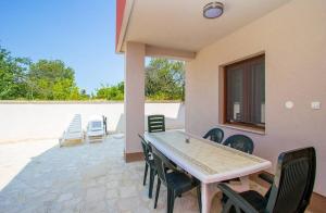 a patio with a table and chairs on a patio at Apartments Racchi in Banjole