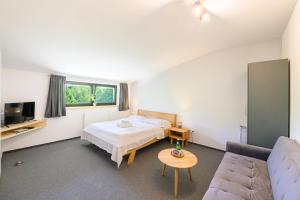 a bedroom with a bed and a couch at Vila Matliare in Tatranská Lomnica
