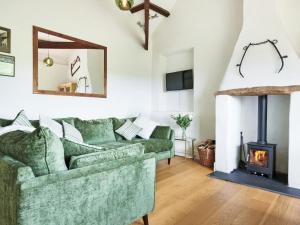 a living room with a green couch and a fireplace at Harvest - Ukc9523 in Barnstaple