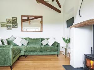 a living room with a green couch and a fireplace at Harvest - Ukc9523 in Barnstaple