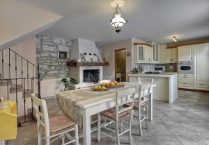 a kitchen with a white table and chairs and a fireplace at Villa Dea in Svetvinčenat