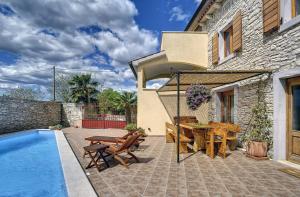 a patio with a table and chairs next to a house at Villa Dea in Svetvinčenat