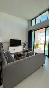 a living room with a large couch and a tv at Pool Villa Maephim 34, by Somjai in Ban Tha Fat