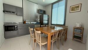 a kitchen with a wooden table and chairs at Pool Villa Maephim 34, by Somjai in Ban Tha Fat