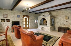 a living room with leather chairs and a stone fireplace at Villa Lucy in Barban