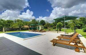 a pool with benches and an umbrella and a playground at Villa Lucy in Barban