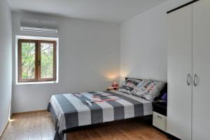 a white bedroom with a bed and a window at Villa BR in Ližnjan +11 photos