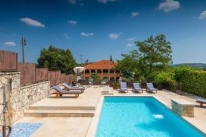 a swimming pool with chairs and a house at House Casa Alberta in Rovinjsko Selo