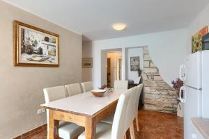 a dining room with a table and a white refrigerator at House Casa Alberta in Rovinjsko Selo