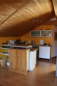 a large kitchen with wooden floors and a wooden ceiling at Bavaria in Seeg +9 photos
