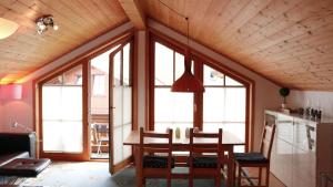 a dining room with a table and some windows at Bavaria in Seeg