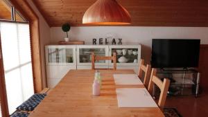 a dining room with a wooden table and a television at Bavaria in Seeg