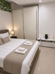 a bedroom with a large bed with two towels on it at Drasa Harmony Apartment in Gjirokastër