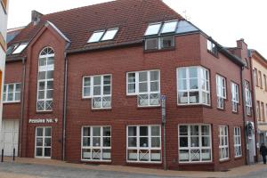 a red brick building with windows on a street at Pension No.9 in Parchim