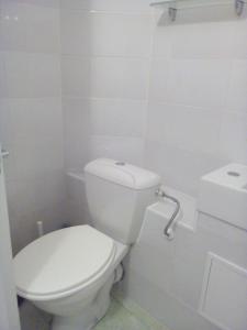 a white bathroom with a toilet and a sink at Sea Apartment in Liepāja