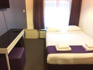 a hotel room with two beds and a window at Hotel Bellington in Amsterdam