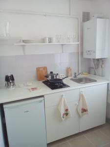 a white kitchen with a stove and a sink at Sea Apartment in Liepāja